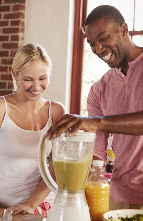 Man and woman using an electric blender to make a smoothie