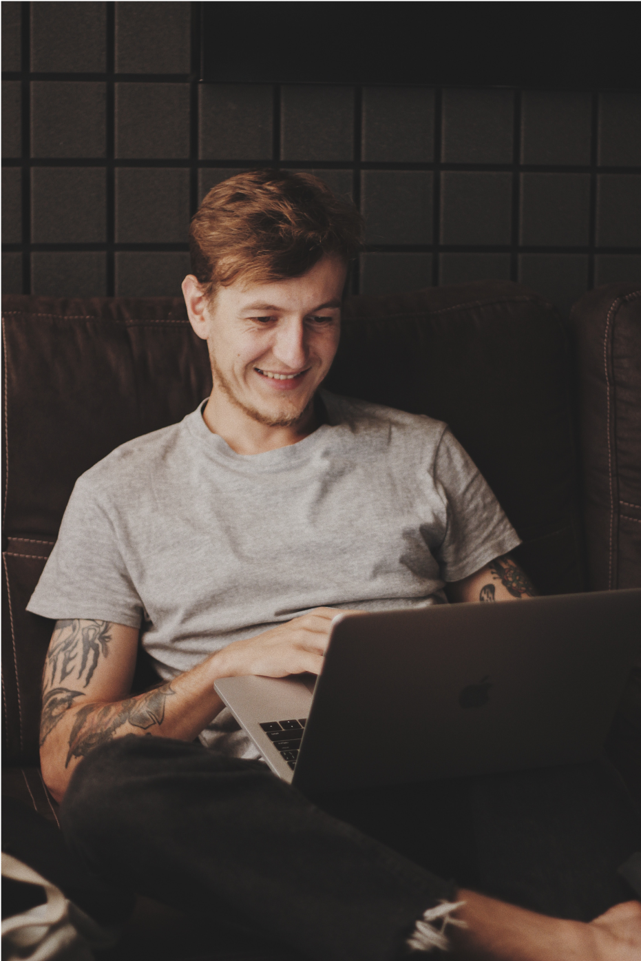Man sitting on the sofa using his laptop to surf the internet.